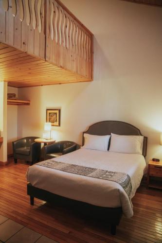 ein Schlafzimmer mit einem großen Bett und einem Stuhl in der Unterkunft Lenroot Lodge in Seeley