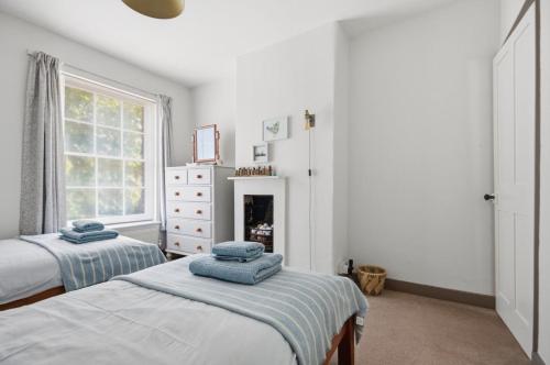 a bedroom with two beds and a fireplace at Coastguards in Southwold