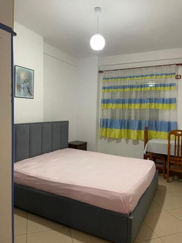 a bedroom with a bed and a table and a window at Endi Apartments 2 in Tirana