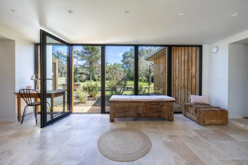 a room with a bed and a table and glass doors at Villa des Résiniers, proche plage & forêt, wifi in Moliets-et-Maa