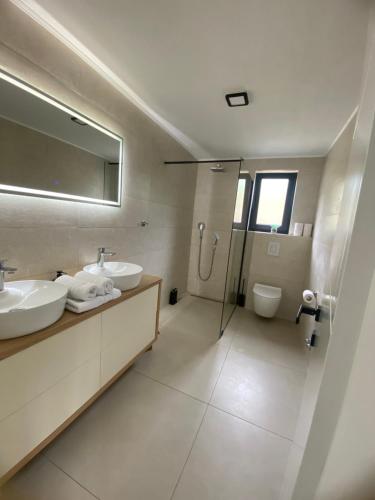a bathroom with two sinks and a shower at Villa Infinity View in Široki Brijeg