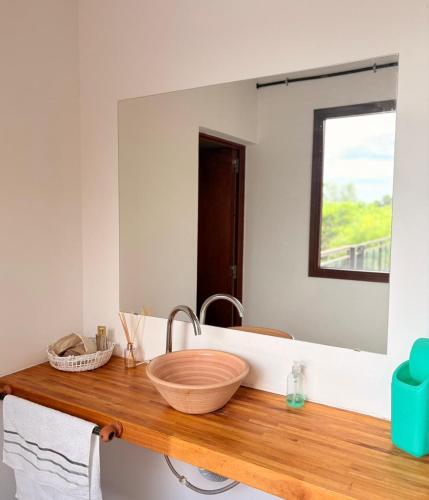 a bathroom with a wooden sink and a mirror at Casa Parque Rio Uruguay in Concordia