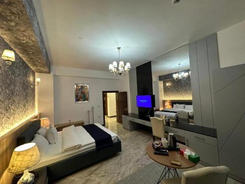a bedroom with a bed and a desk and a television at Motel Victoria Sky in Erbil