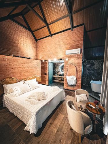 a bedroom with a large bed and a bathroom at A Estalagem hospedaria in Flores da Cunha