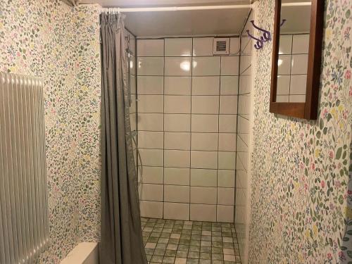 a shower with a shower curtain in a bathroom at Charmig lägenhet nära Smögenbryggan in Smögen