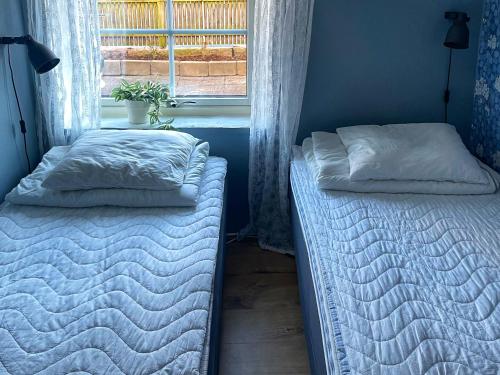 two beds in a room with a window at Charmig lägenhet nära Smögenbryggan in Smögen