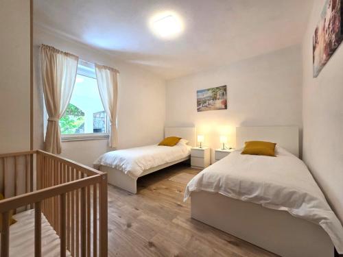 a bedroom with two beds and a staircase at Apartman Filip in Risika