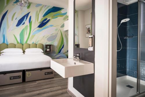 a bathroom with a bed and a sink and a shower at The RomeHello in Rome