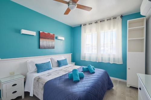 a bedroom with blue walls and a bed with blue pillows at Apartamentos Eldorado in Lloret de Mar