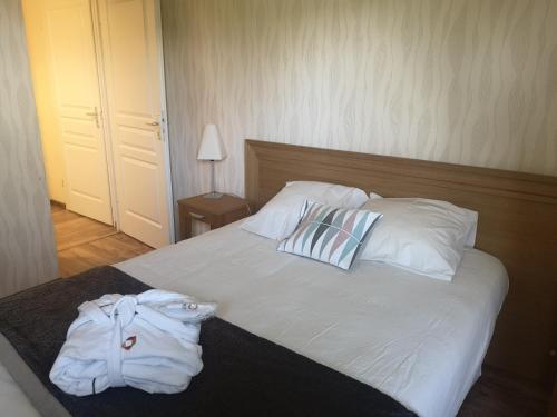 a bedroom with a bed with white sheets and pillows at Domitys Le Côteau d'Argent in Saint-Doulchard
