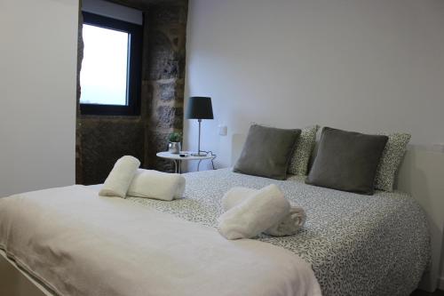 a bedroom with a white bed with pillows and a window at Recanto da Malhadoira in Currais