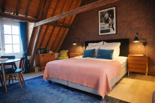 a bedroom with a bed and a table and a window at Koffie&kussens in Middelburg