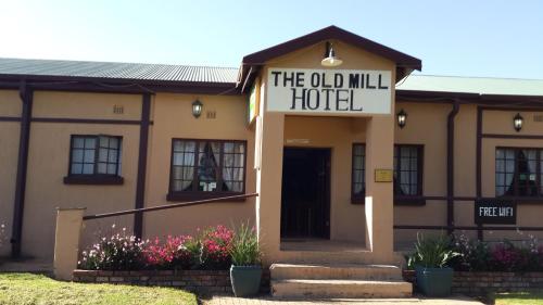 a building with a sign that reads the old mill hotel at The Old Mill Hotel in Machadodorp