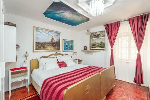 a bedroom with a bed with a red and white striped blanket at Mia Casa Dubrovnik in Dubrovnik
