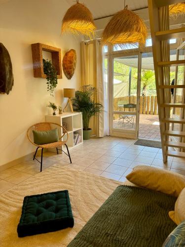 a living room with a stairway and a room with a chair at L'Oliveraie de Paul in Aigues-Mortes