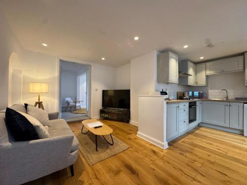 a kitchen and living room with a couch and a table at The Snuggery - Windermere, The Lake District in Bowness-on-Windermere
