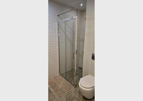 a bathroom with a toilet and a glass shower at Lumina OVO2 in Wrocław