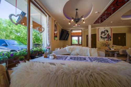 a large bedroom with a large white bed with a large window at Residence Spa Harenda in Zakopane