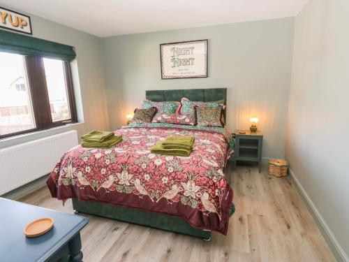 a bedroom with a bed with a red comforter at Underview in Holmfirth