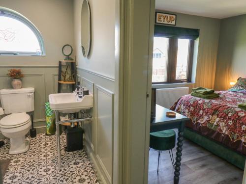 a bathroom with a sink and a toilet and a bed at Underview in Holmfirth