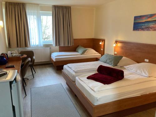 a hotel room with two beds and a couch at Hotel Oyten am Markt Bremen in Oyten