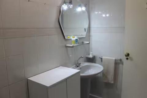 a white bathroom with a sink and a mirror at Sweet West in Lourinhã