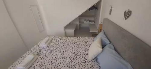 a small bedroom with a bed and a staircase at Sweet West in Lourinhã