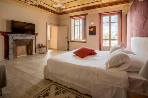 a bedroom with a large white bed with a fireplace at OLIVOLA APARTMENTS in Frassinello