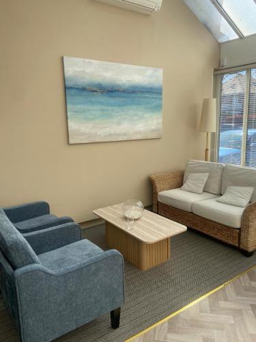 a living room with two chairs and a couch and a table at The Windsor House Hotel in Worthing