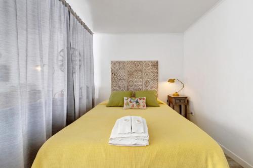 a bedroom with a yellow bed with a yellow blanket at Casa Do Canto in Cascais