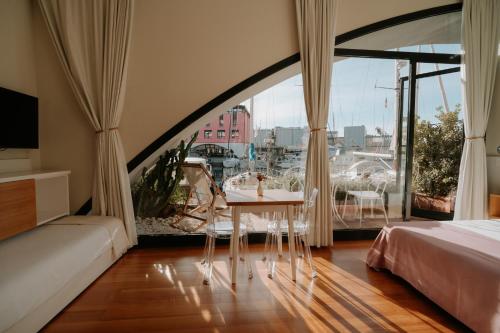 a bedroom with a table and a large window at Locanda da Toto in Genoa
