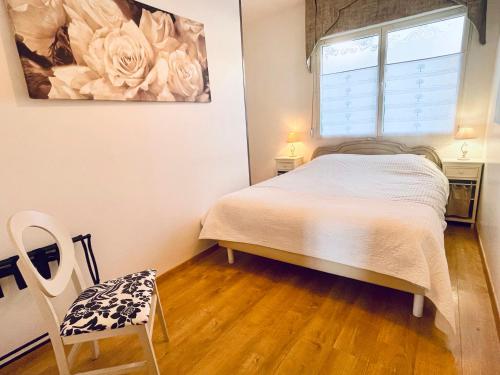 a bedroom with a bed and a window and a chair at Villa des Sarcelles in Le Crotoy