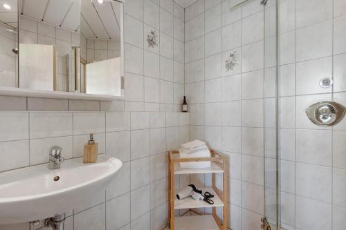 a white bathroom with a sink and a shower at Apartment mit Gartenblick K1 206 in Spalt