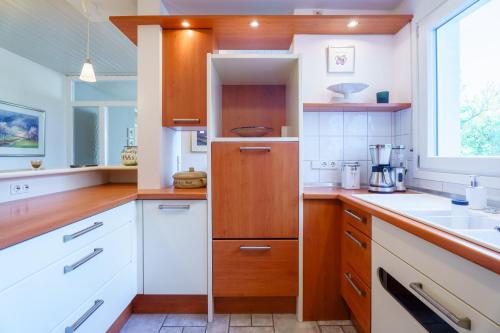 a kitchen with white counters and wooden cabinets at Alm-Atelier in Durbach