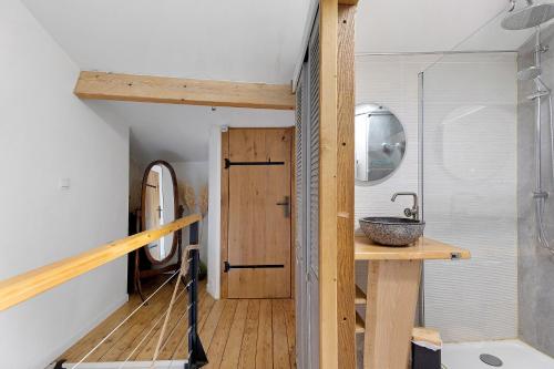 a bathroom with a sink and a wooden door at Gite À La Tite Boulite in Vouneuil-sous-Biard