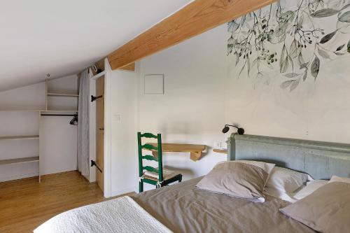 a bedroom with a bed and a painting on the wall at Gite À La Tite Boulite in Vouneuil-sous-Biard
