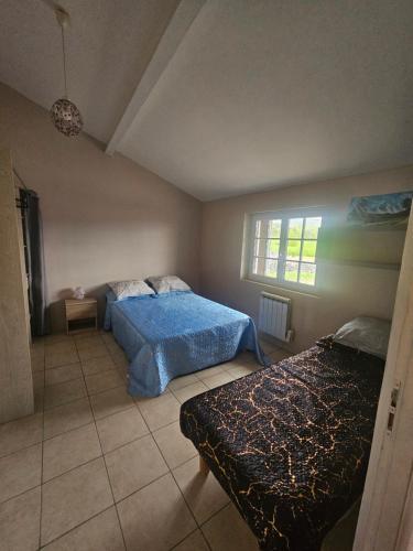 a bedroom with two beds and a window at Appartement T2 in Vaugneray