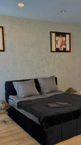 a bedroom with a large bed with a black blanket at Black Pearl Jacuzzi Apartament in Sopot