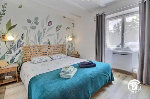 a bedroom with a bed with a blue comforter at Le tigîte b&b in Allaire