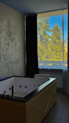 a bathroom with a bath tub with a large window at Black Pearl Jacuzzi Apartament in Sopot