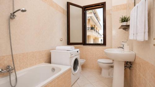 a bathroom with a toilet a sink and a bath tub at Casa Rosada Alghero in Alghero