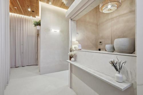 a hallway with white walls and a large mirror at The Maida Hotel in London