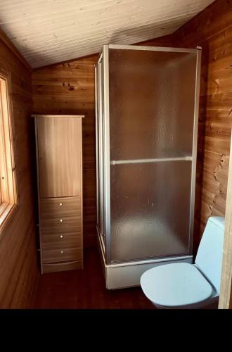 a refrigerator and a toilet in a room at Cabin at the Gate to Österlen in Degeberga