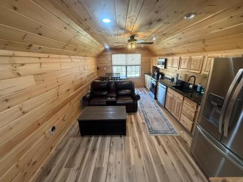 a log cabin with a couch and a kitchen at Small Cabin Over Garage with lake access and small dock in Sevierville