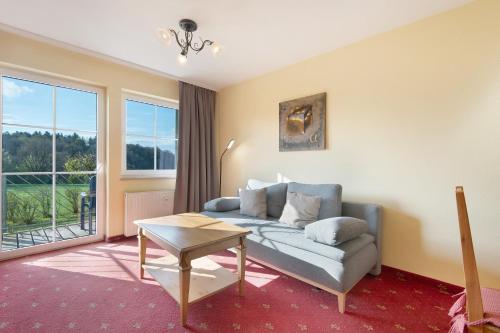 a living room with a couch and a table at Superior Apt mit Seeblick K2 002 in Spalt