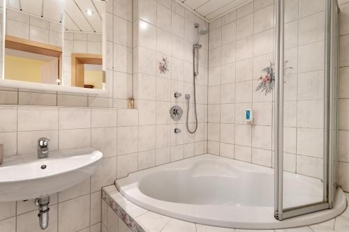 a white bathroom with a tub and a sink at Superior Apt mit Seeblick K2 002 in Spalt