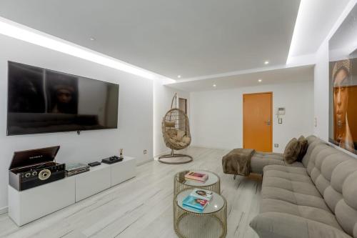 a living room with a couch and a tv at Spacious 3-bedroom condo near Lisbon Airport in Lisbon