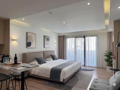 a bedroom with a large bed and a table at CCLUX Suites - Premium 40sqm Suites near Piraeus Port in Piraeus