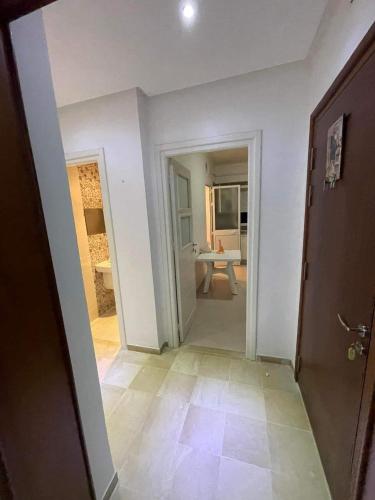 an empty room with a hallway with a table in it at HERGLA Sousse Zone Touristique in Harqalah