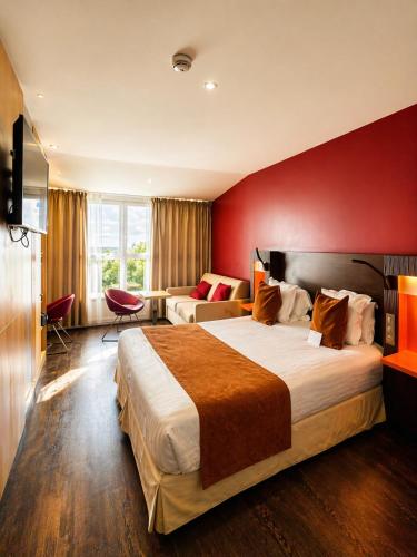 a hotel room with a large bed and a red wall at Best Western Seine West Hotel in Puteaux
